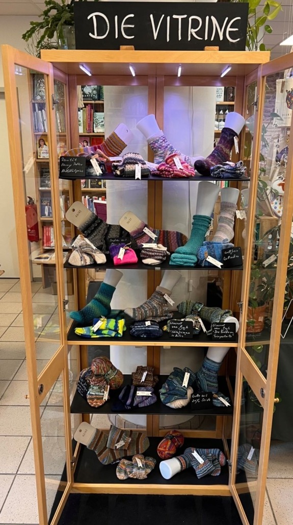 Die Vitrine in den Bücherträumen in Mülheim an der Ruhr mit Wollsocken als kreative Geschenkideen