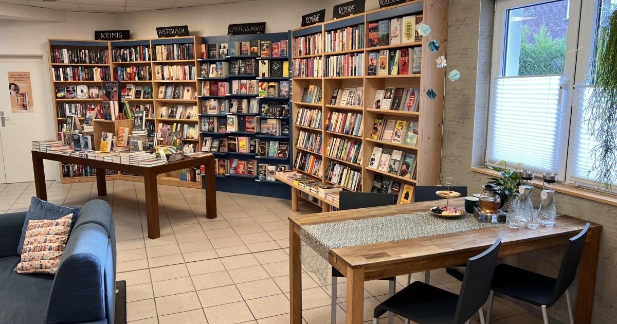 Innenansicht der Buchhandlung Bücherträume in Mülheim an der Ruhr mit einem gedeckten Tisch im Vordergrund, der zum gemütlichen Lesen einlädt