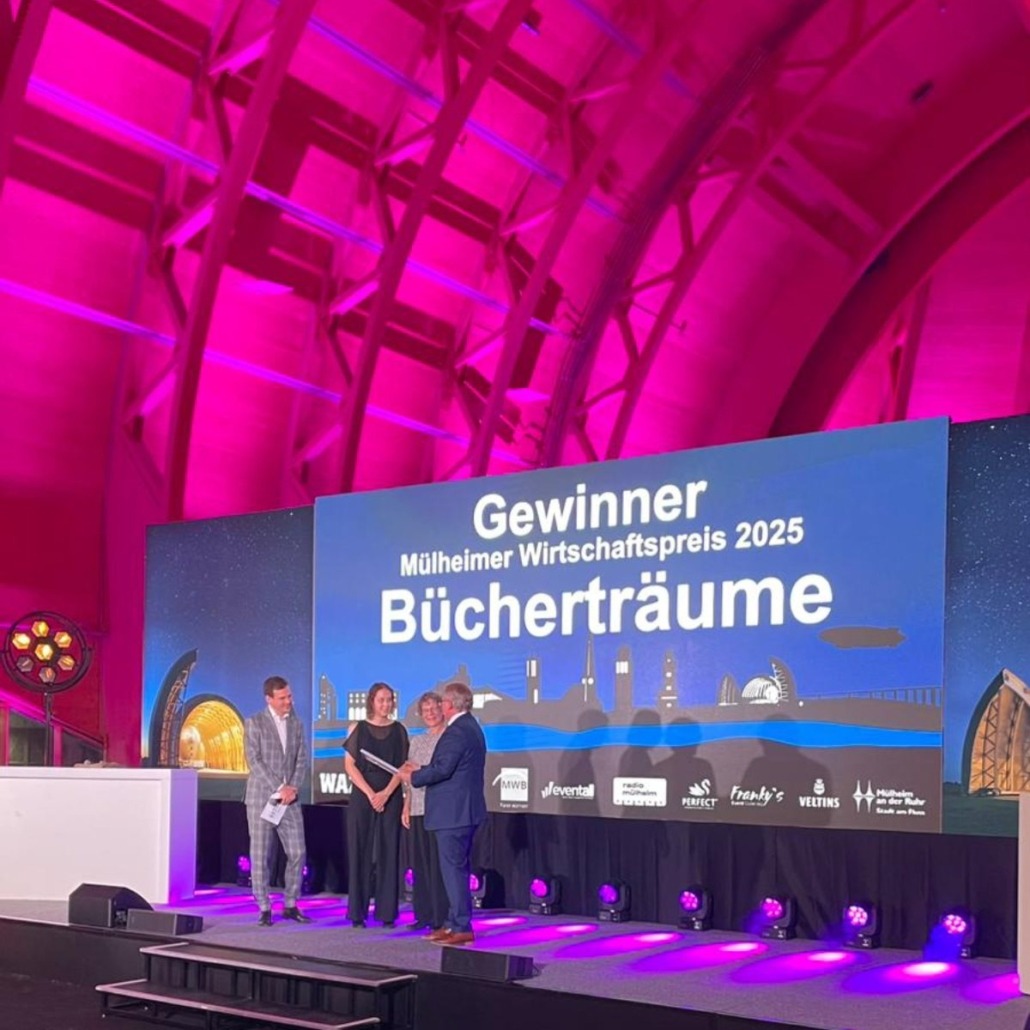 Wirtschaftspreis Gewinnerbild der Bücherträume, die 2025 den Mülheimer Wirtschaftspreis für ihr unternehmerisches Engagement gewonnen haben, hier bei der Preisverleihung durch OB Buchholz im WDL Luftschiffhangar.