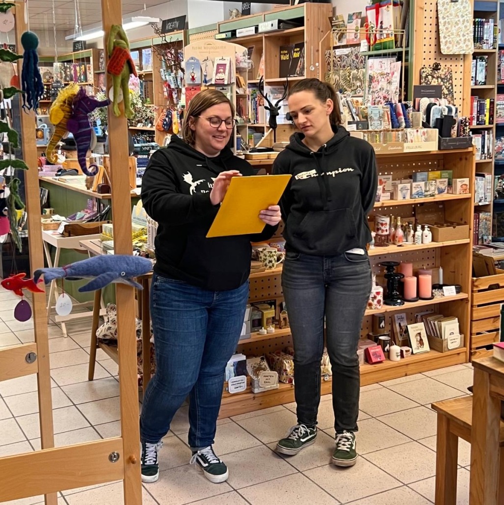 Einblick in eine Spielrunde Blood on the Clocktower in den Bücherträumen in Mülheim an der Ruhr. Zwei Frauen diskutieren über ihre Rollen