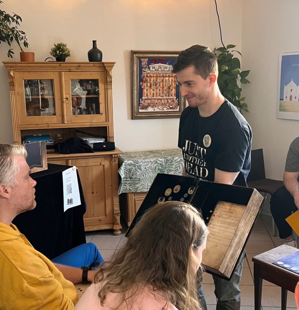Einblick in eine Spielrunde Blood on the Clocktower in den Bücherträumen in Mülheim an der Ruhr. Der Storyteller zeigt dem Spion das Grimoire.