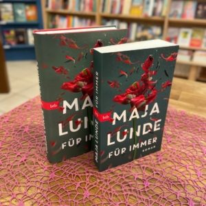 Das Bild zeigt den Unterschied zwischen einem Hardcover Buch und einem Taschenbuch, beide Male mit dem selben Titel.