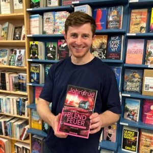 Unser Buchhändler hält das Buch "Blendfeuer" von Ingar Johnsrud in der Hand, zu dem er eine Rezension geschrieben hat.